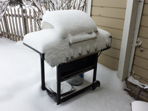 barbeque grill covered in snow